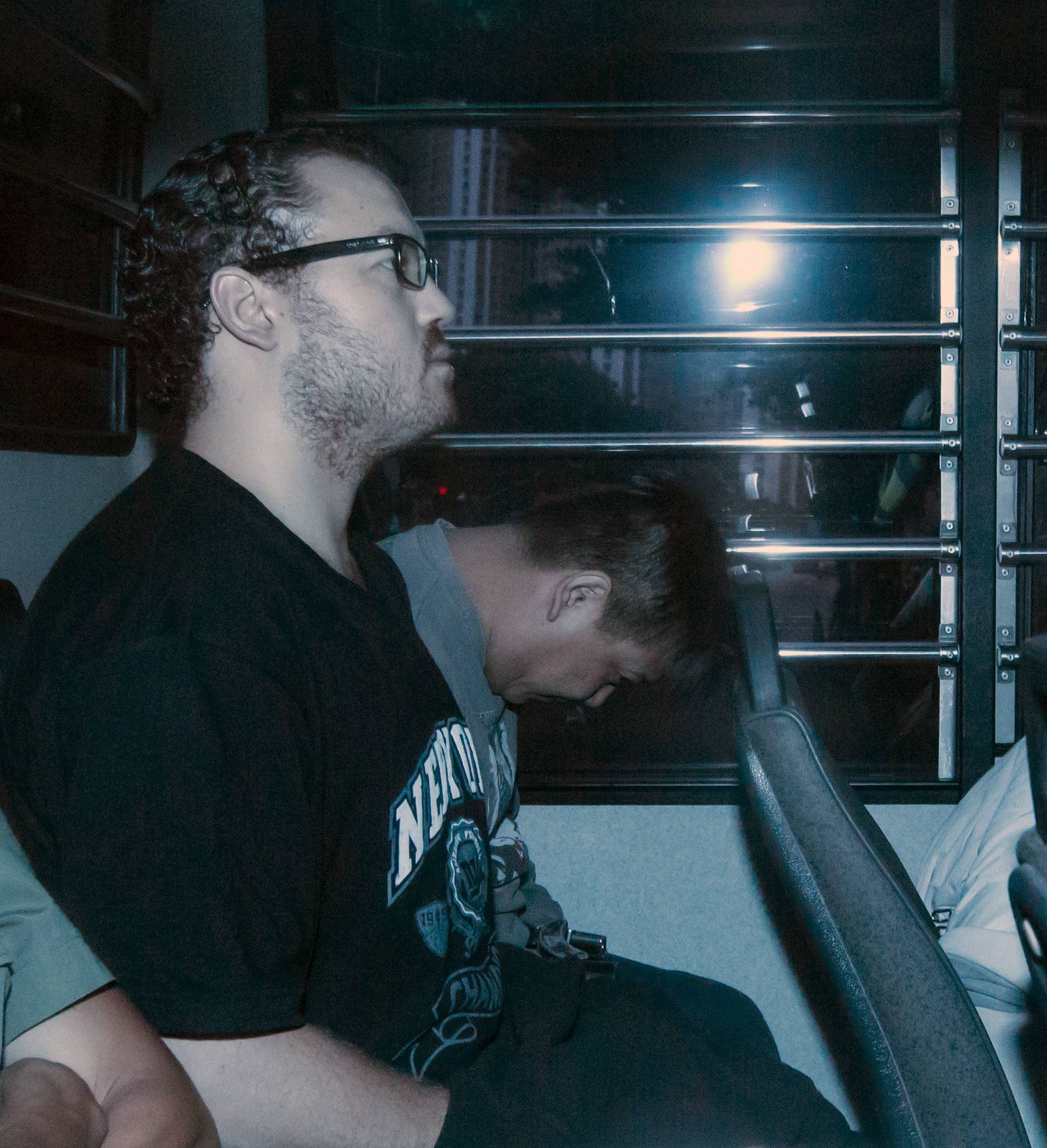 Rurik George Caton Jutting, a British banker charged with two counts of murder after police found the bodies of two women in his apartment, sits in the back row of a prison bus as he arrives at the Eastern Law Courts in Hong Kong, China