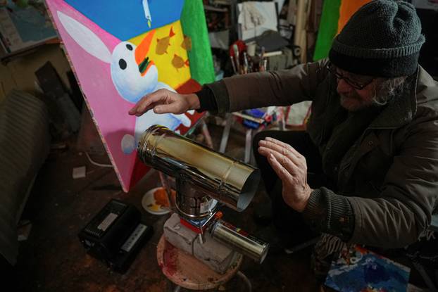 Ukrainian artist works at his studio during a power blackout in Kyiv