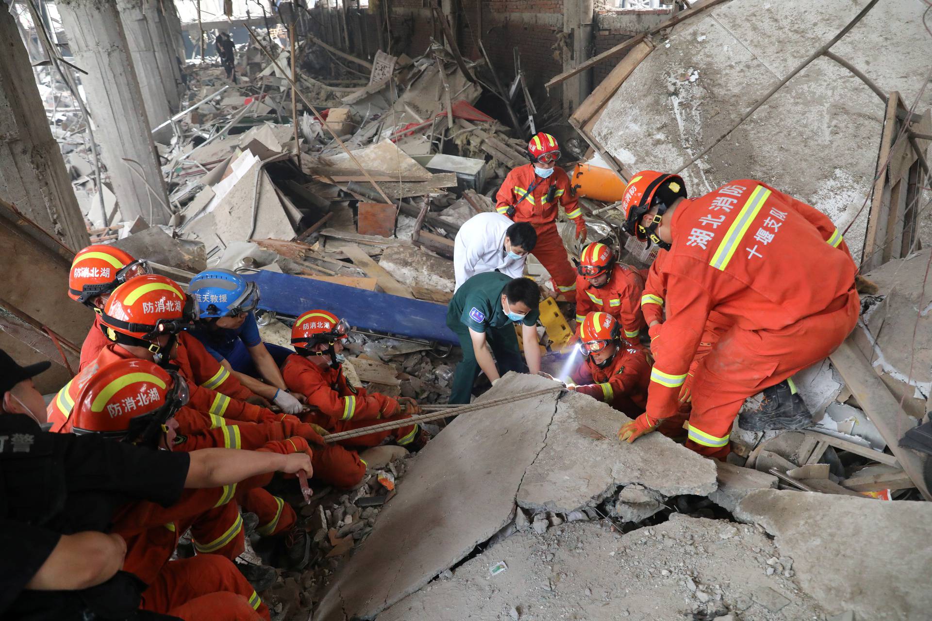 Rescue workers search for victims amid the debris following a gas pipeline explosion in Shiyan