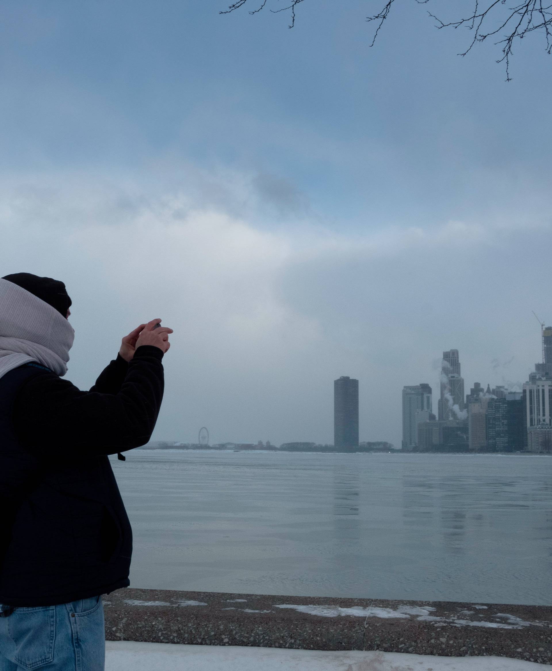 Jim Cleary takes a photo of the city skyline from the North Avenue Beach at Lake Michigan in Chicago