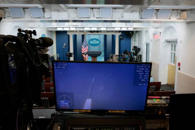 A television monitor in the White House briefing room shows the Artemis II launch