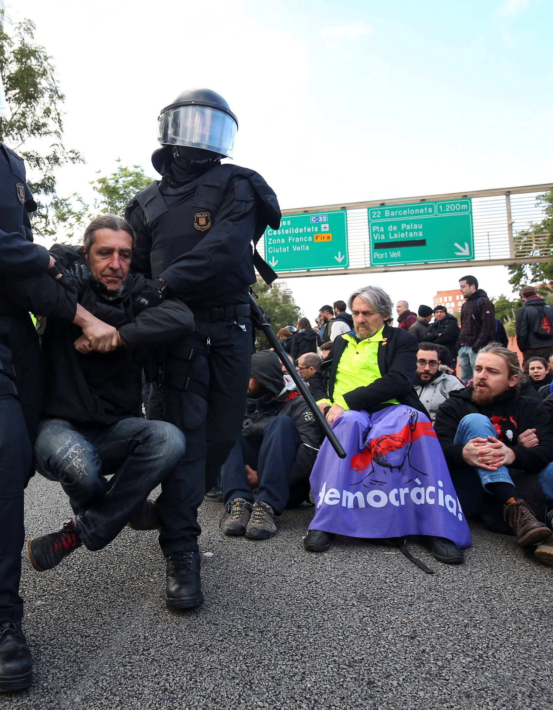 Police remove protestors blocking a ring road in Barcelona during a partial regional strike in Barcelona