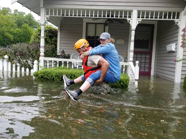 Handout photo of a Texas National Guard soldier carries a woman on his bank as they conduct rescue operations in flooded areas around Houston