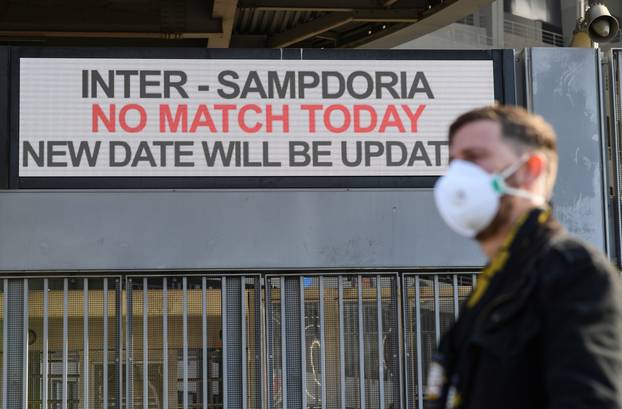 A man wearing a face mask stands outside the San Siro stadium after the Inter Milan v Sampdoria Serie A match was cancelled due to an outbreak of the coronavirus in Lombardy and Veneto, in Milan