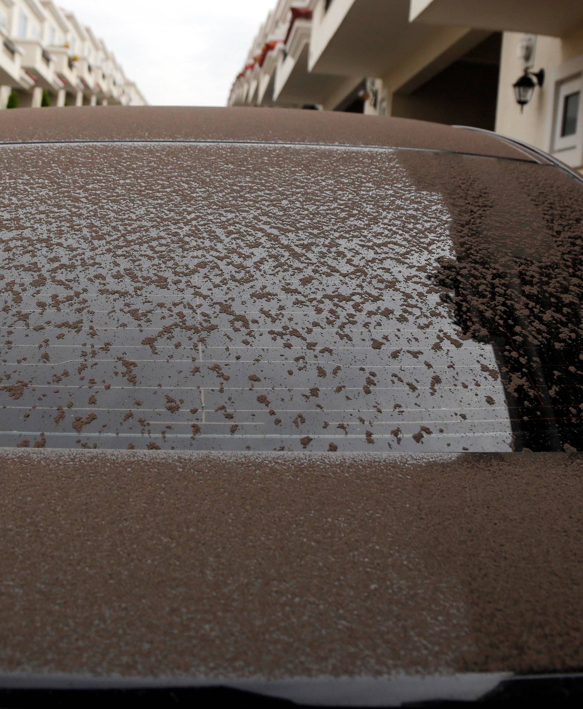 A car is partially covered with ash after Fuego volcano erupted violently, in Guatemala City