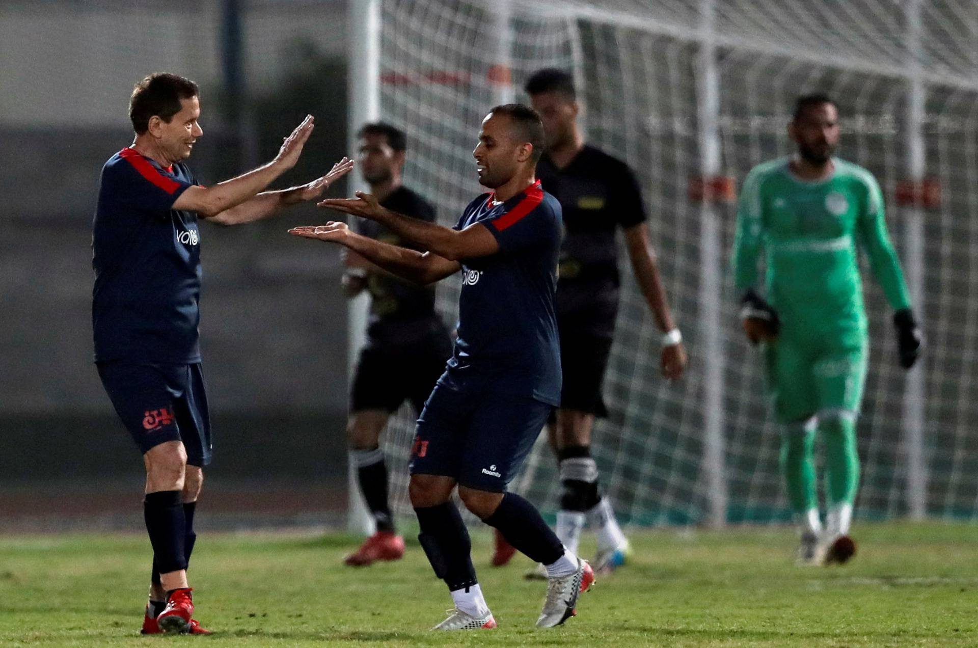 Ezzeldin Bahader, a 74-years-old Egyptian football player of 6th October Club celebrates with players after a soccer match against El Ayat Sports Club of Egypt's third division league at the Olympic Stadium in the Cairo suburb of Maadi