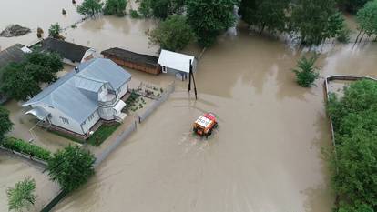 Rescuers ride inside amphibious vehicle through flooded residential area in Chernivtsi region