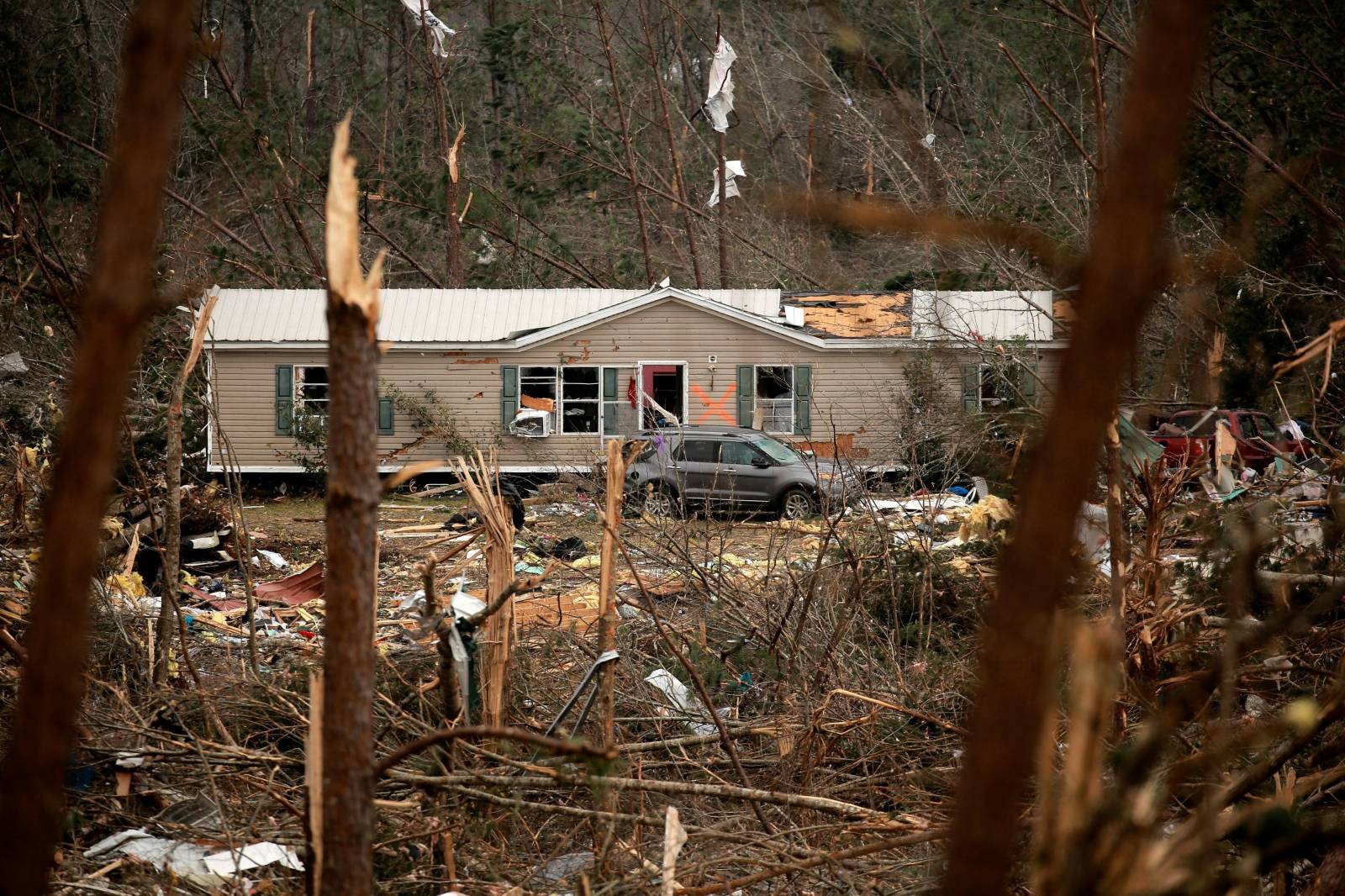 A house with an X painted on it is seen across a hillside of wreckage after two deadly back-to-back tornadoes, in Beauregard, Alabama