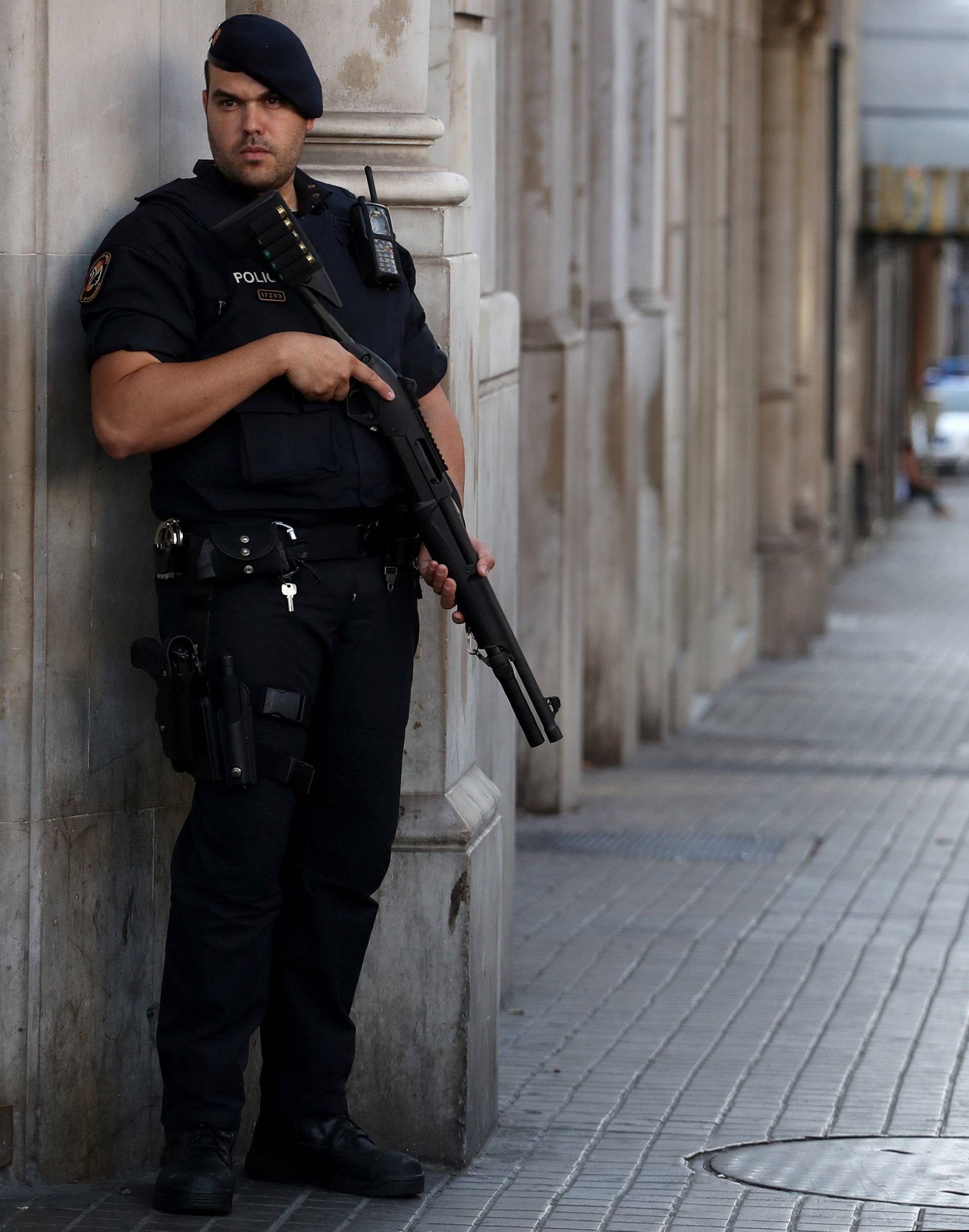 Armed Catalan Mossos d'esquadra officers stand guard at Las Ramblas street where a van crashed into pedestrians in Barcelona