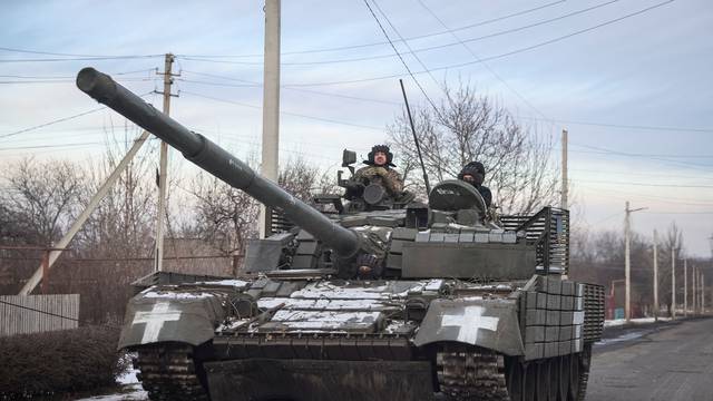 Ukrainian service members ride a tank near the frontline town of Bakhmut