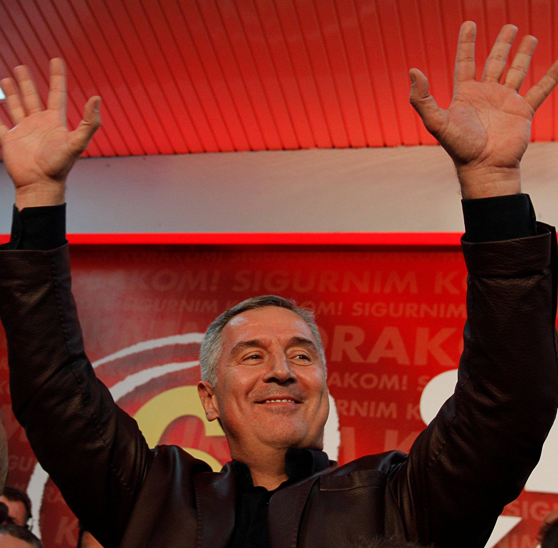 Montenegrin Prime Minister and leader of ruling Democratic Party of Socialist Milo Djukanovic wave to supporters after the parliamentary elections in Podgorica