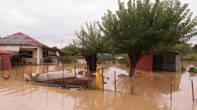 A local is seen in the yard of his flooded house following a storm near the village of Artesiano