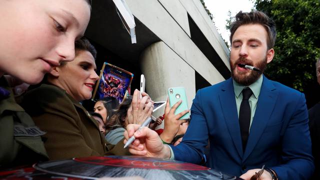 Cast member Chris Evans signs autographs for fans on the red carpet at the world premiere of the film "The Avengers: Endgame" in Los Angeles