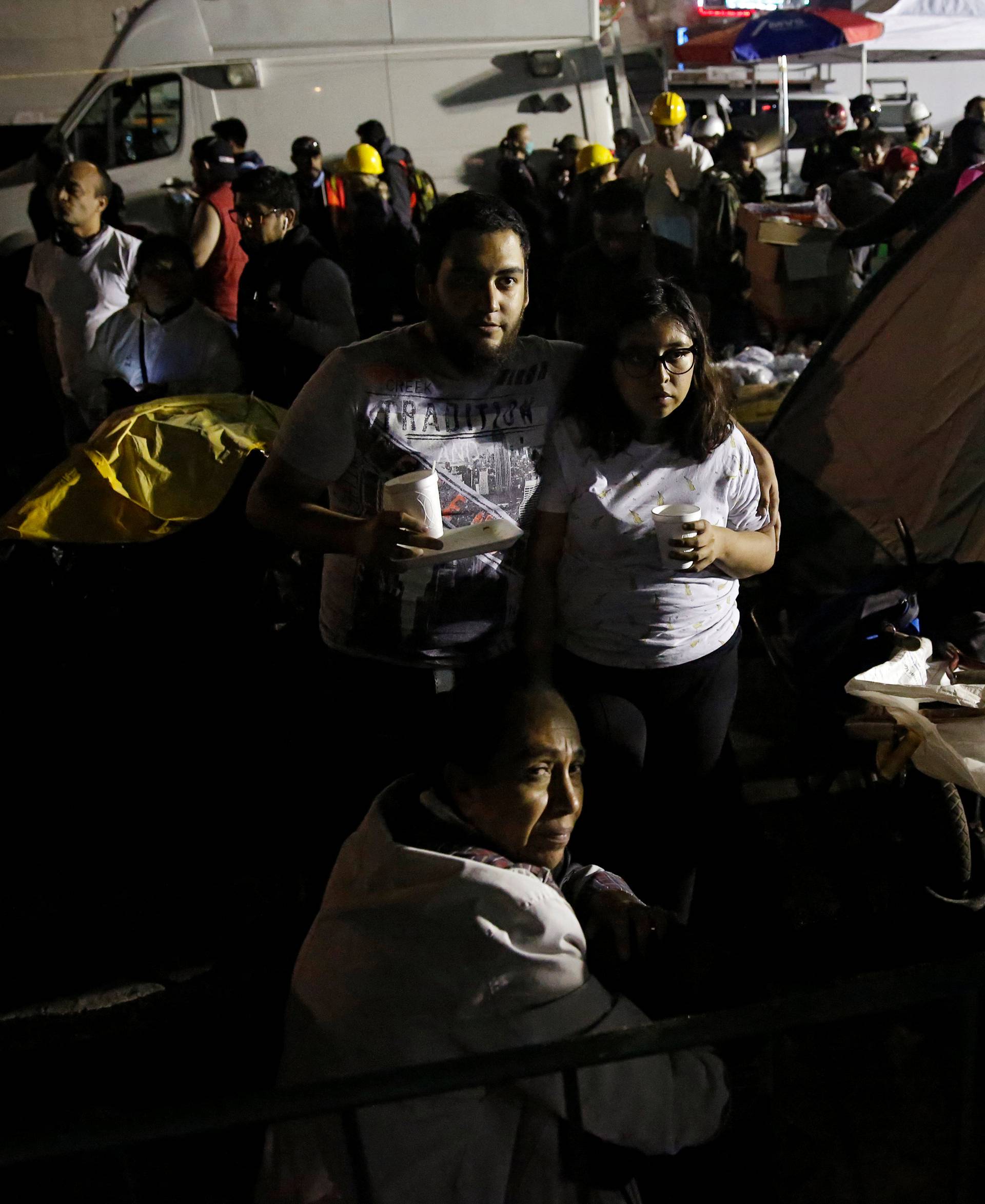 Relatives wait for news of their loved ones next to a collapsed building after an earthquake in Mexico City,