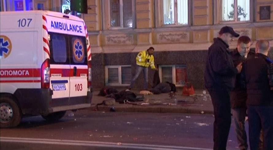 A still image taken from a video shot on October 18, 2017, shows bodies laying on the ground next to an ambulance at the accident scene after a car drove into pedestrians following a vehicle collision in central Kharkiv