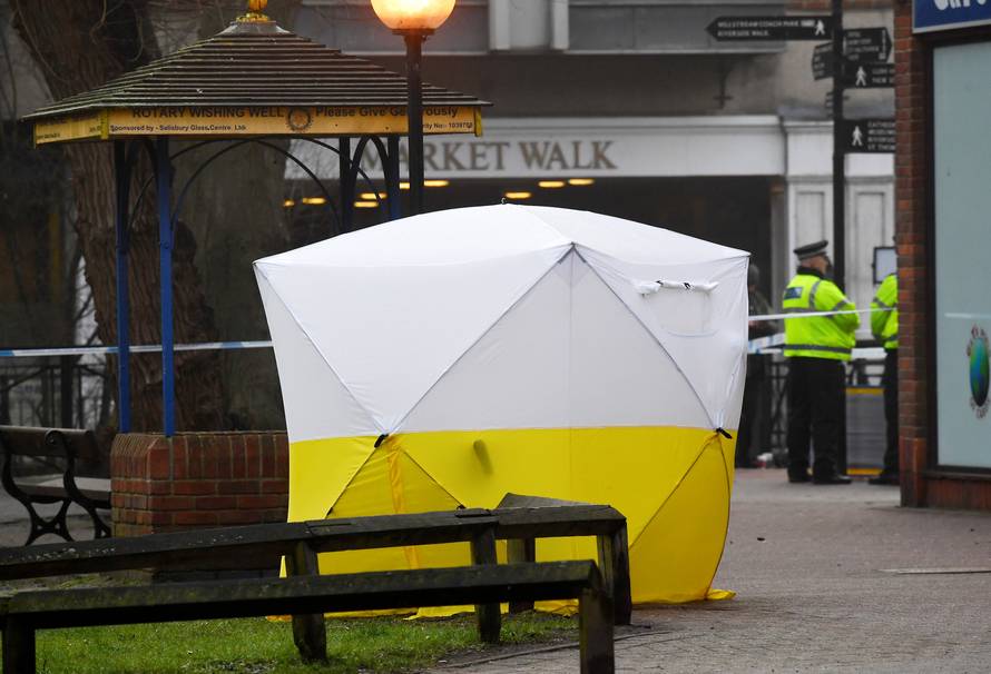 Police officers stand at crime scene tape, as a tent covers a park bench on which former Russian inteligence officer Sergei Skripal, and a woman were found unconscious after they had been exposed to an unknown substance, in Salisbury