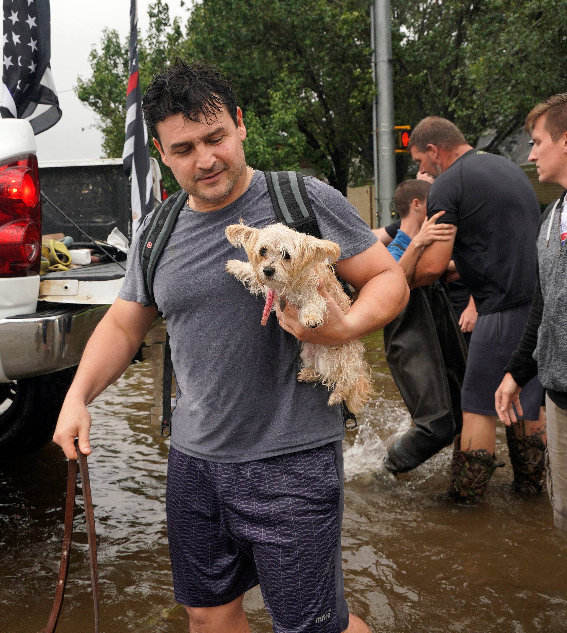 A man holds his dog after being evacuated by boat from the Hurricane Harvey floodwaters in Houston
