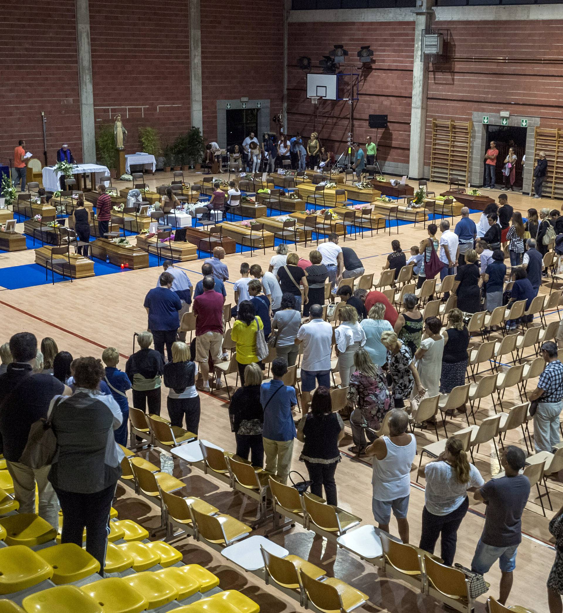 Coffins of some of the victims of the earthquake in central Italy are seen inside a gym in Ascoli Piceno