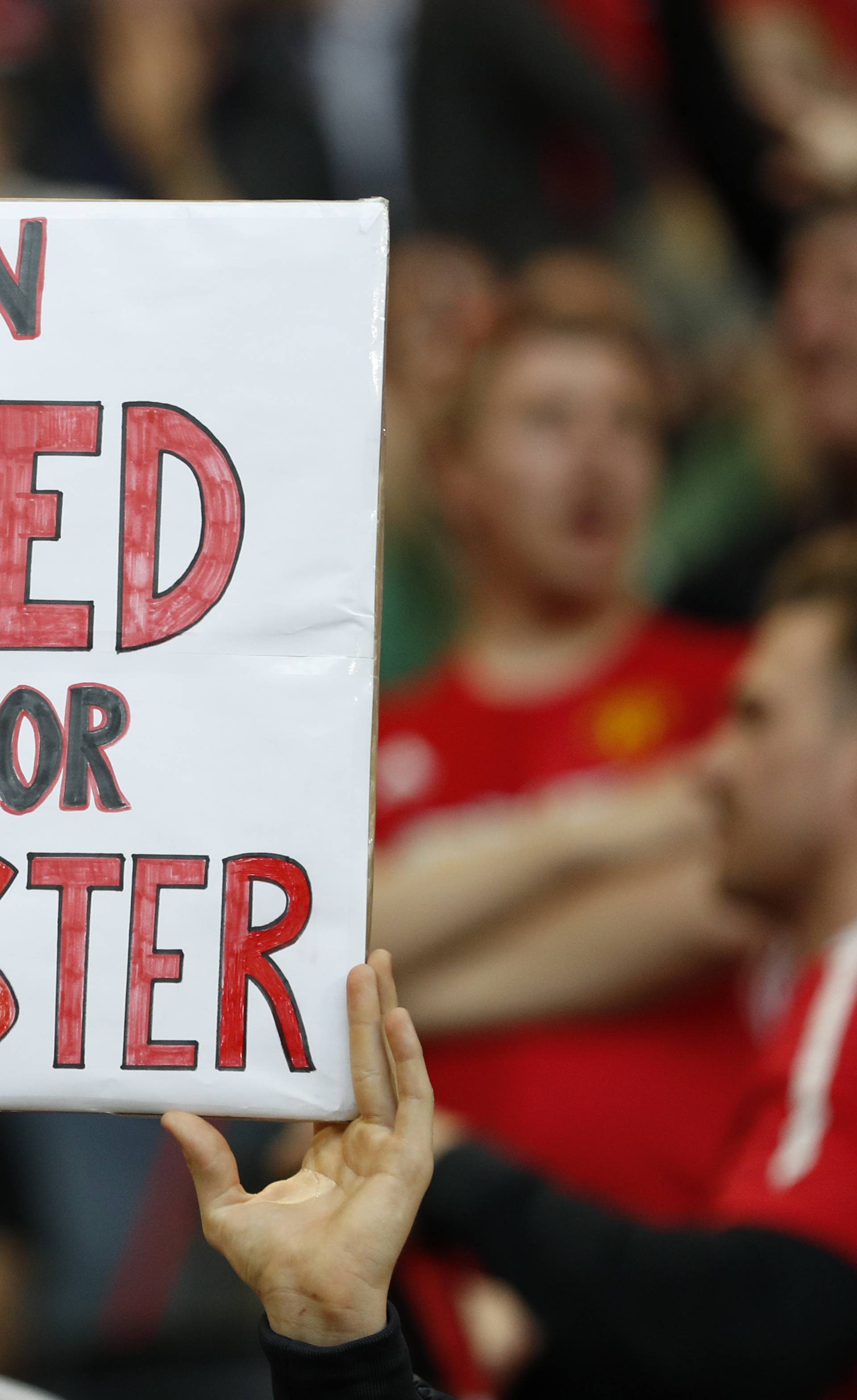 Manchester United fan with a banner in tribute to the victims of the Manchester attack