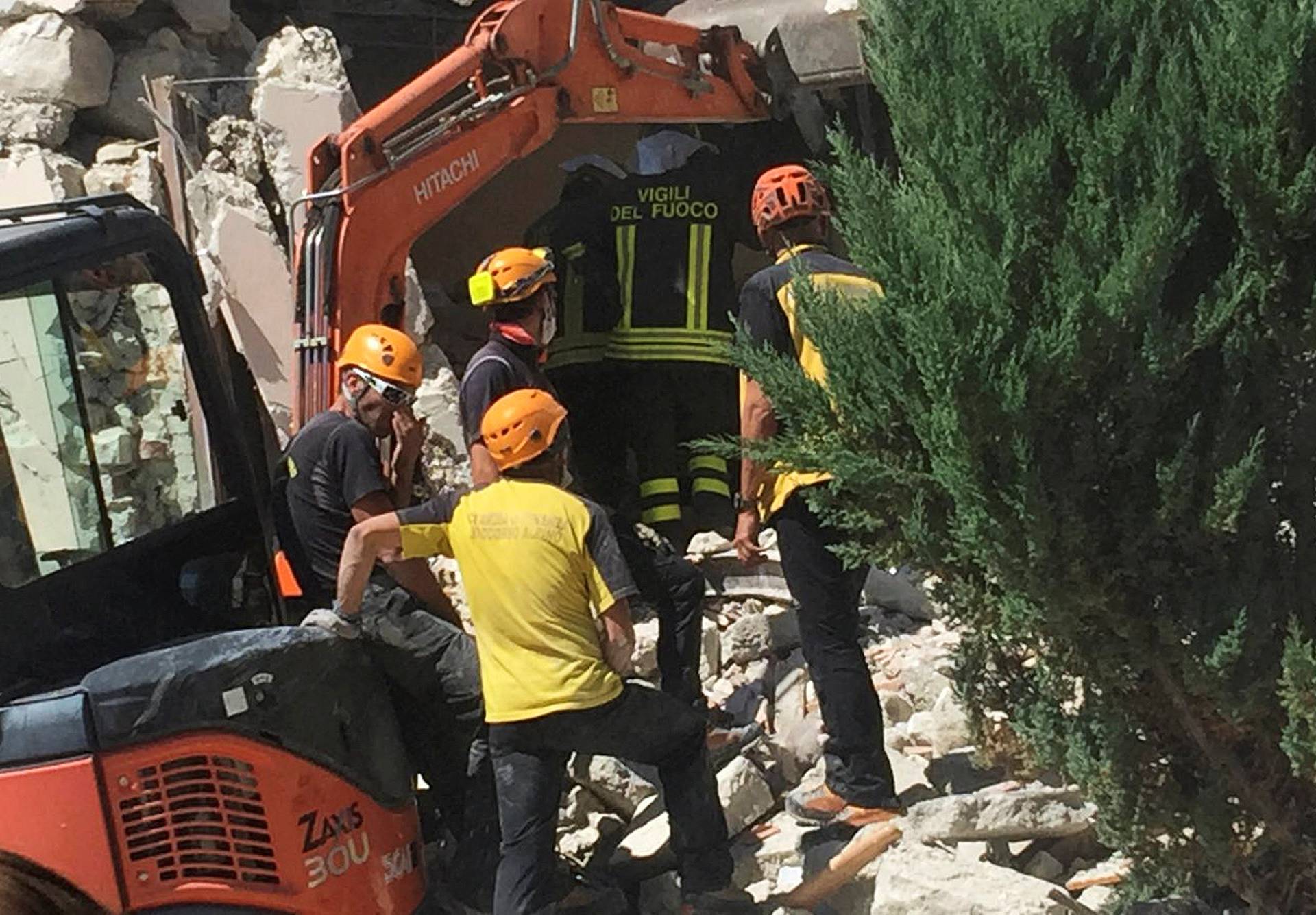 Rescuers work at a collapsed house following an earthquake in Accumoli di Rieti
