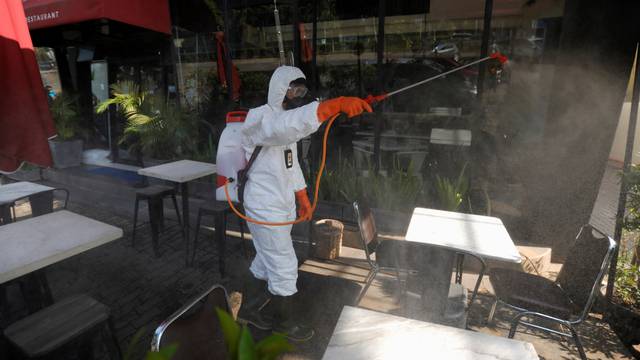 Indonesia's Red Cross personnel sprays disinfectant outside a restaurant at a department store amid the spread of coronavirus (COVID-19) in Jakarta