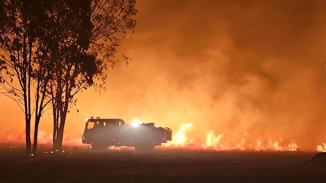 A supplied image shows QFES ground crews responding to a fire in Millmerran