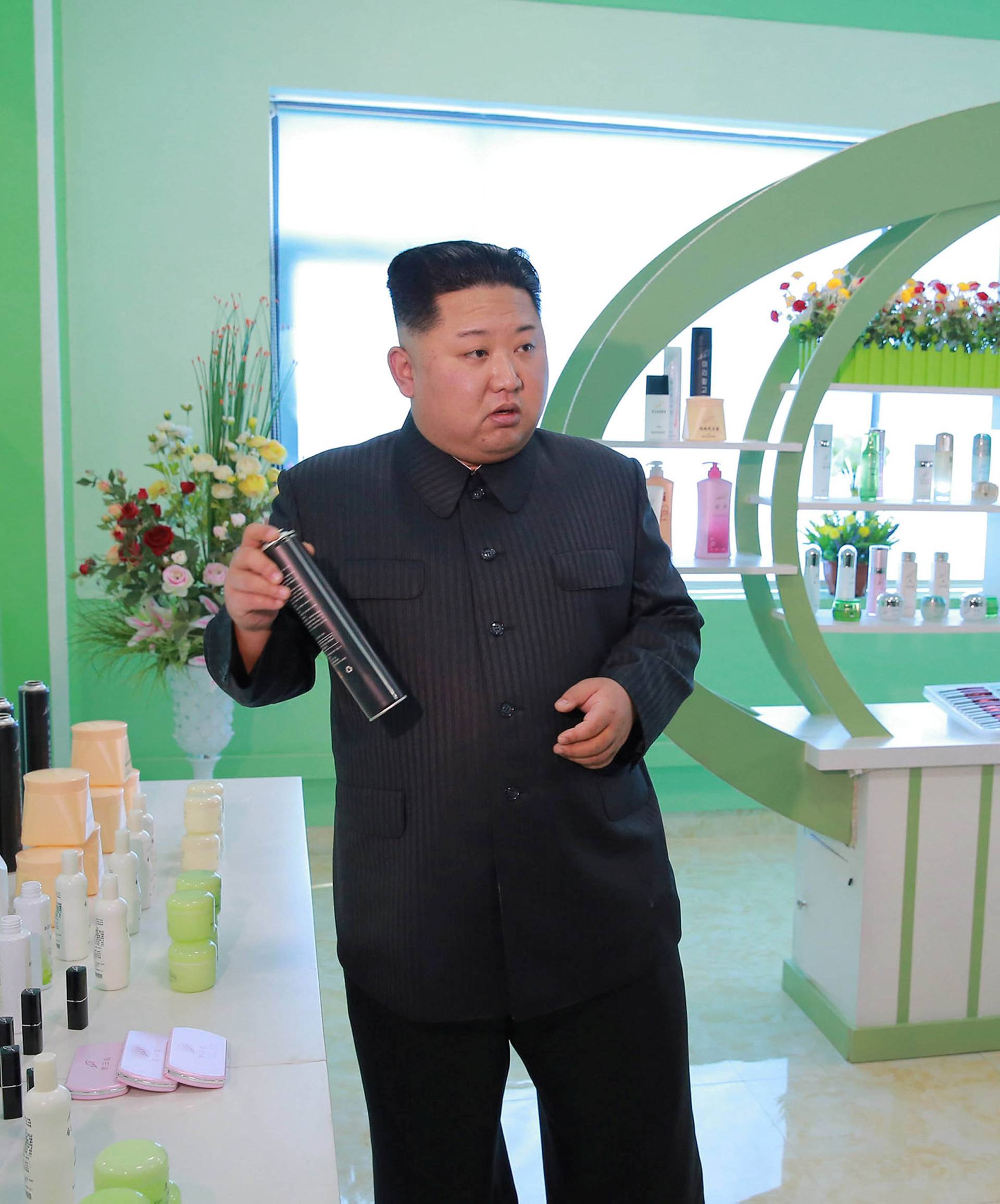 North Korean leader Kim Jong Un and wife Ri Sol Ju visit a cosmetics factory in this undated photo released by North Korea's Korean Central News Agency (KCNA) in Pyongyang