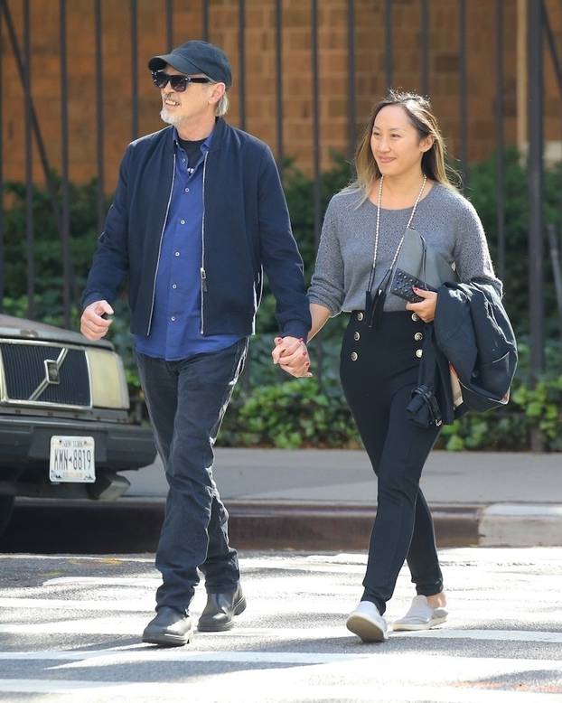 Steve Buscemi walks through New York City holding his young girlfriend by the hand