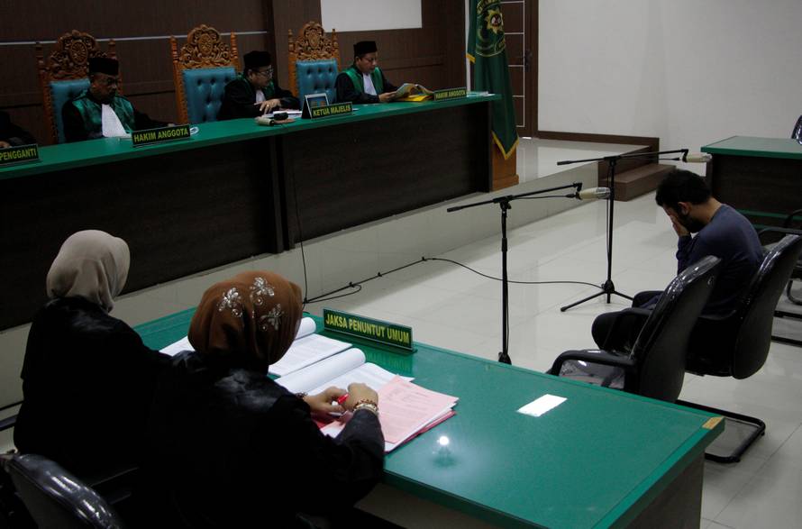 An Indonesian man sits in an Islamic court, one of the two men sentenced to 85 lashes of the cane for having sex together, in Banda Aceh, Aceh province, Indonesia