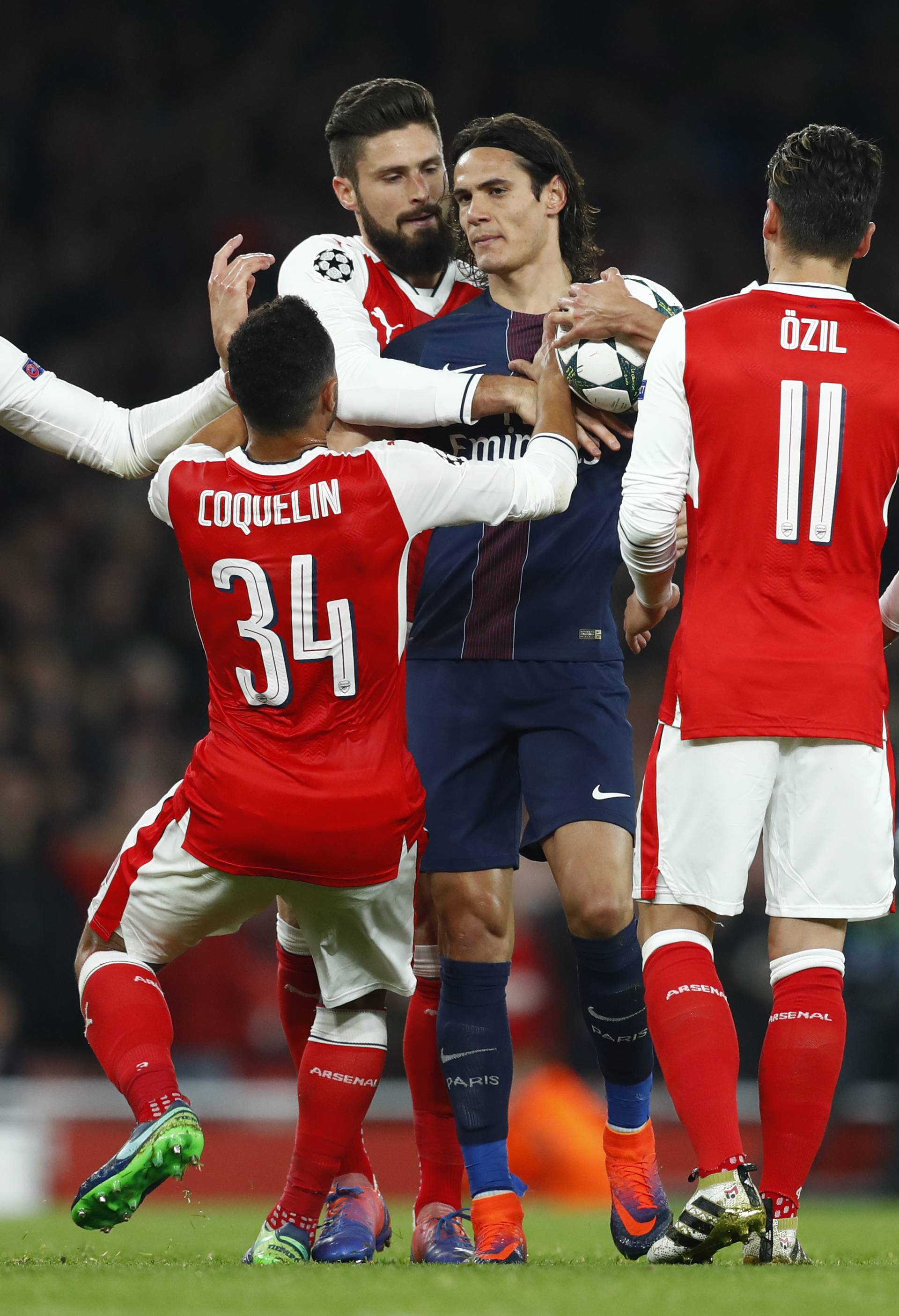 Paris Saint-Germain's Edinson Cavani holds onto the ball as Arsenal's Aaron Ramsey, Francis Coquelin, Olivier Giroud and Mesut Ozil attempt to reclaim it to take the penalty kick