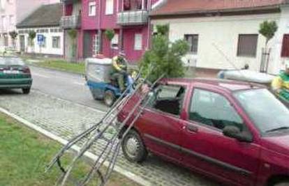 Metalni okvir za drvo pao na parkirani automobil