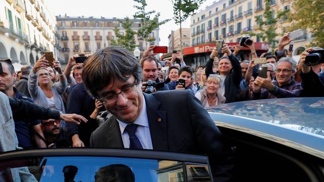 Sacked Catalan President Carles Puigdemont gets into his car after a walkabout through the center of town the day after the Catalan regional parliament declared independence from Spain in Girona