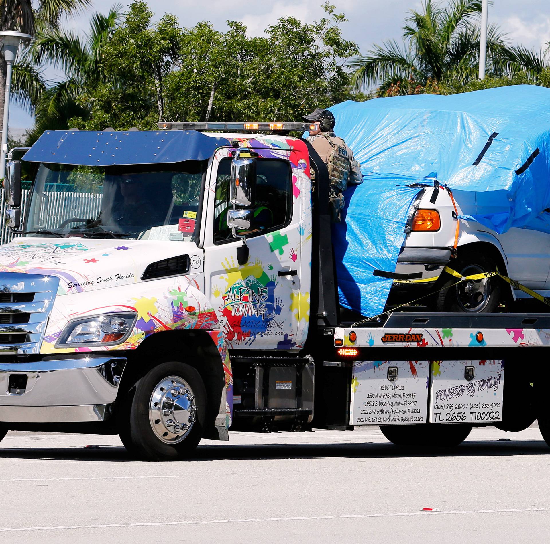 A white van seized during an investigation into a series of parcel bombs is towed into FBI headquarters in Miramar