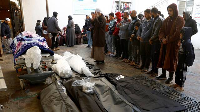 Mourners react next to the bodies of Palestinians killed in Israeli strikes, in Rafah