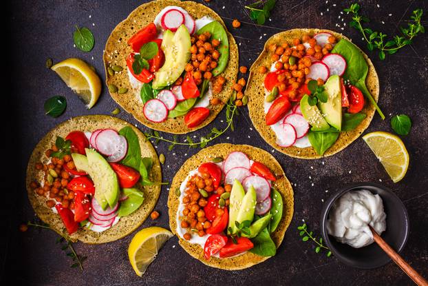 Vegan tacos with baked chickpeas, avocado, sauce and vegetables 