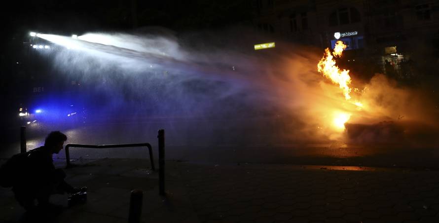 Police uses a water cannon to extinguish a burning barricade following the G20 summit in Hamburg
