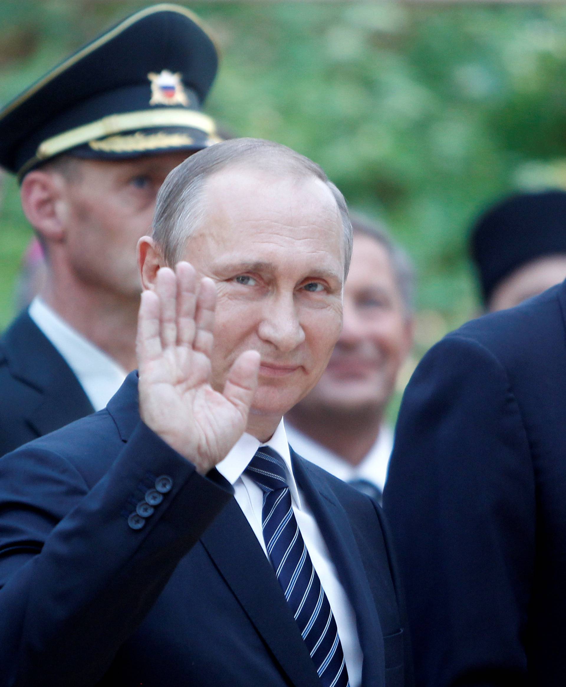 Russian President Vladimir Putin wawes as he attends  the commemoration of 100 years of  the Russian chapel with Slovenia's President Borut Pahor in Vrsic