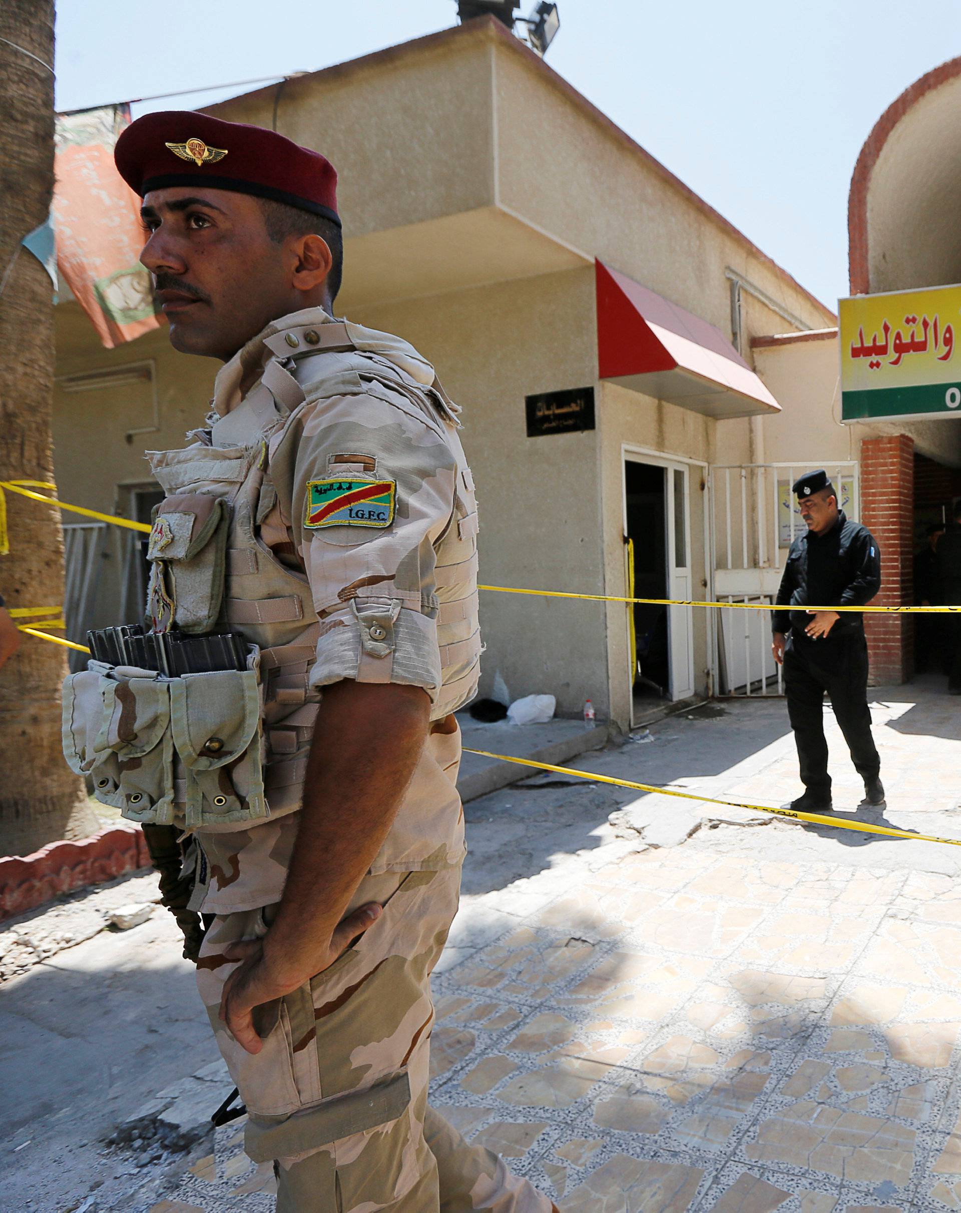 Iraqi security forces stand guard in front of a maternity ward after a fire broke out at Yarmouk hospital in Baghdad