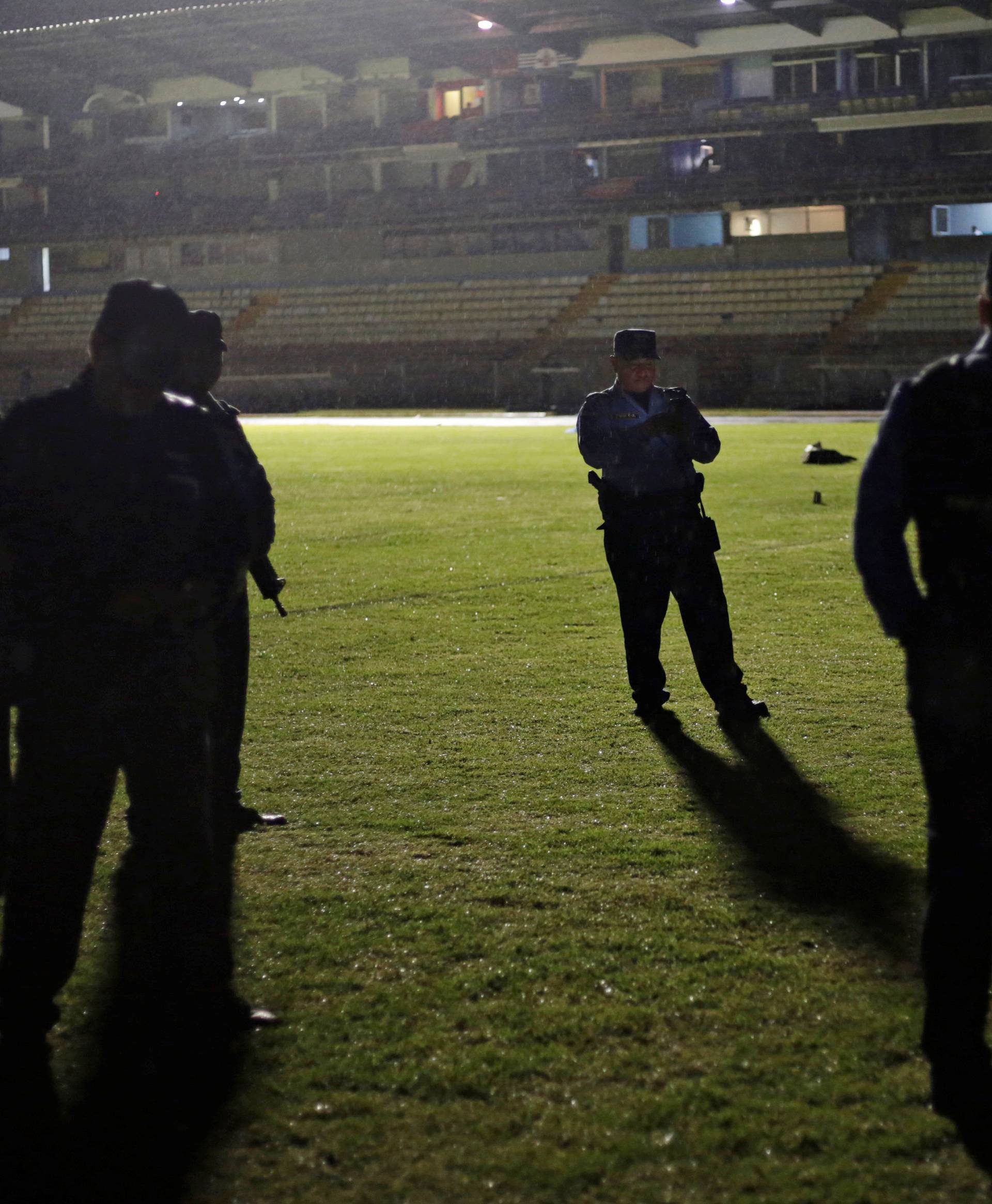 Police officers keep watch after three people died in riots before a soccer match when the fans attacked a bus carrying one of the teams, inside the National Stadium in Tegucigalpa