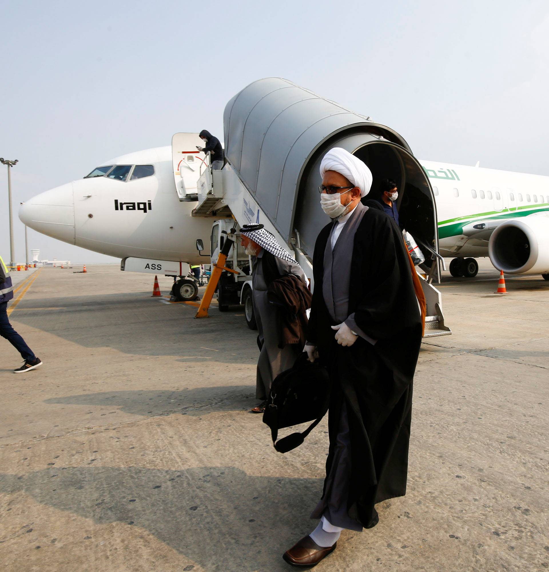 A cleric man wears a protective mask amid concerns over the coronavirus (COVID-19) spread, at Najaf airport in the holy city of Najaf