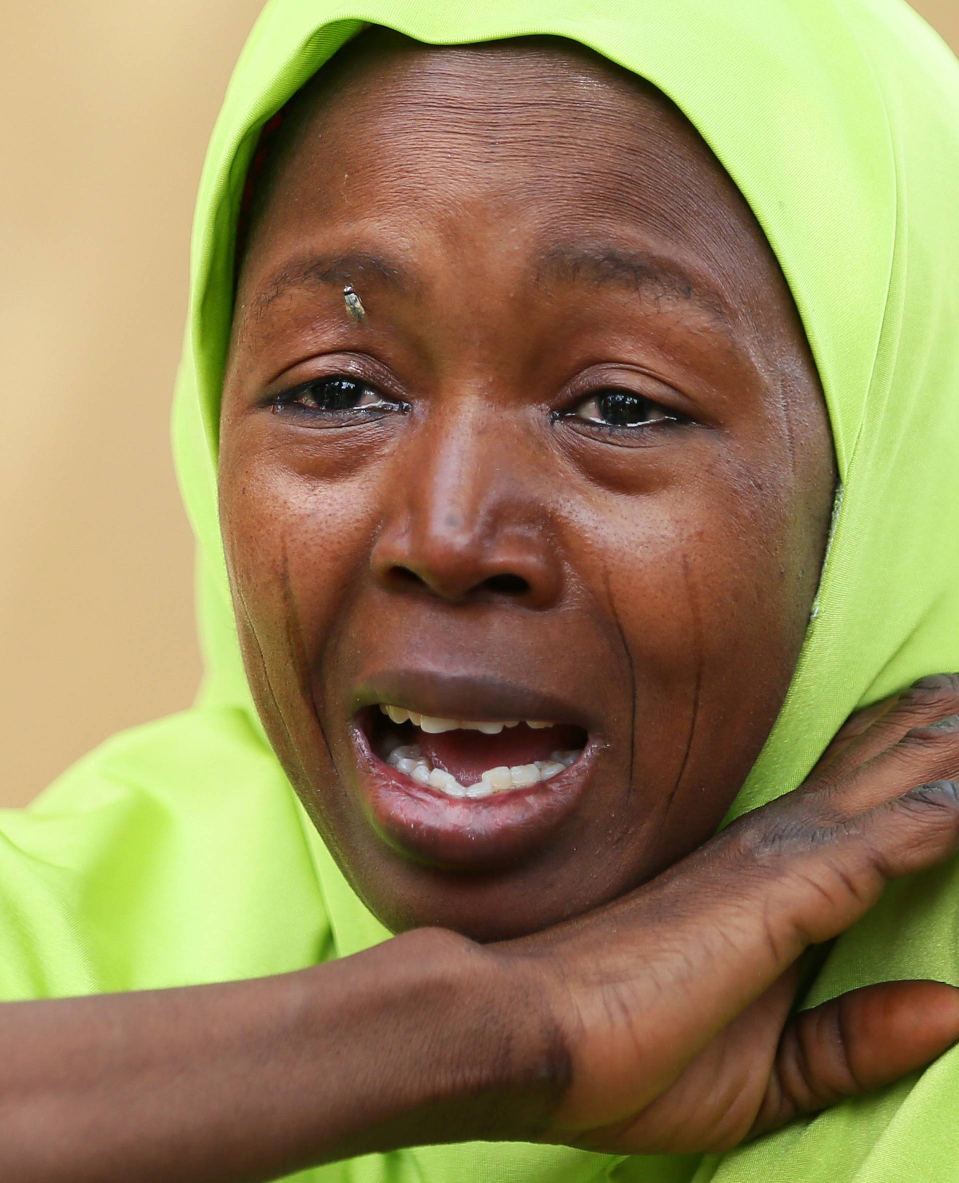 A relative of one of the missing school girls reacts in Dapchi in the northeastern state of Yobe