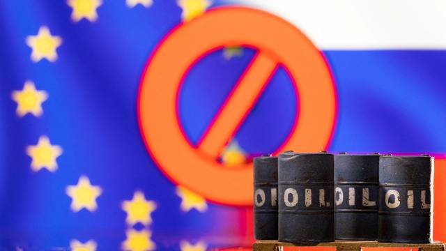 FILE PHOTO: Illustration shows Models of oil barrels in front of sign "stop", EU and Russia flag colours