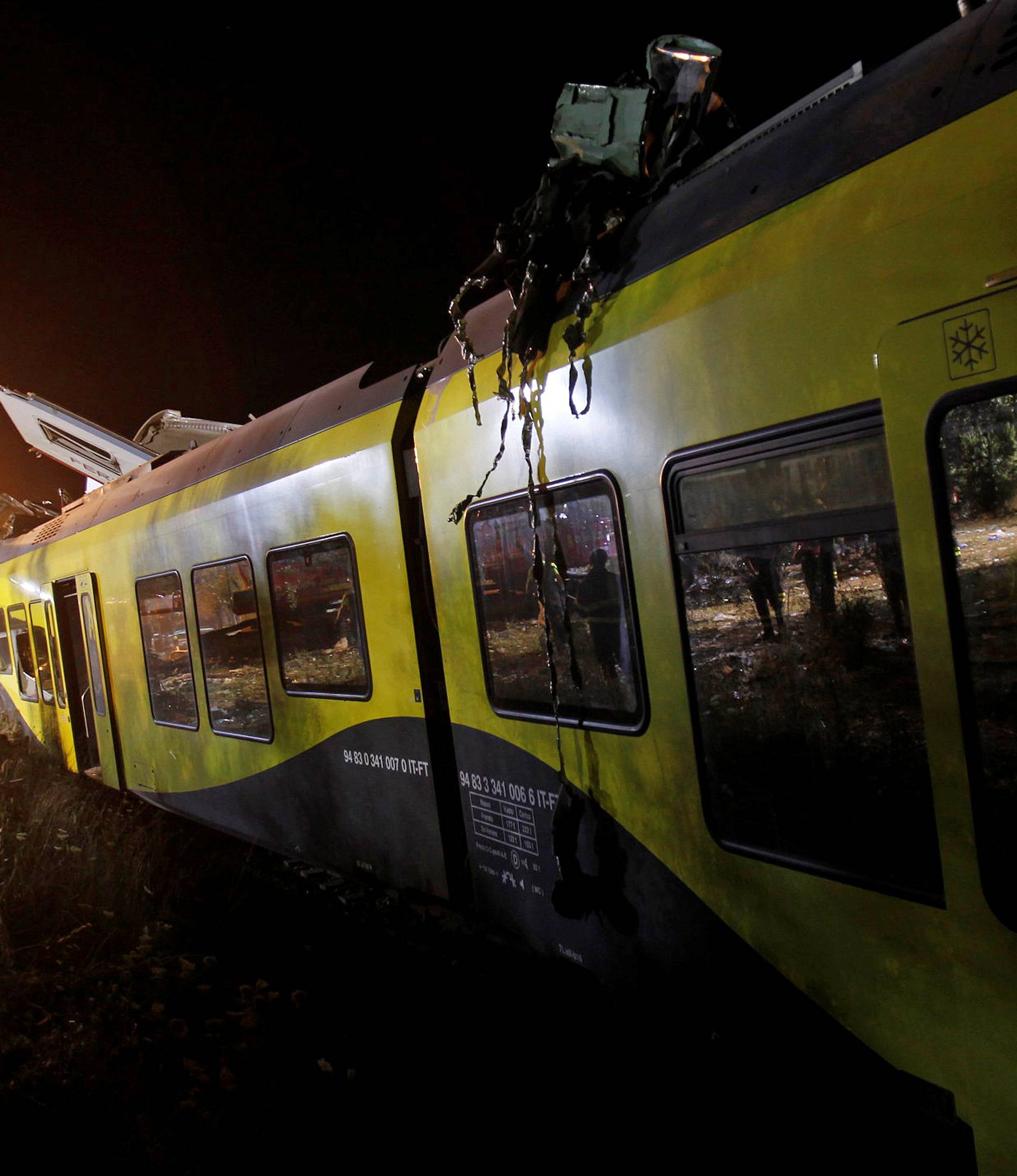 A rescuer works at the site where two passenger trains collided in the middle of an olive grove in the southern village of Corato