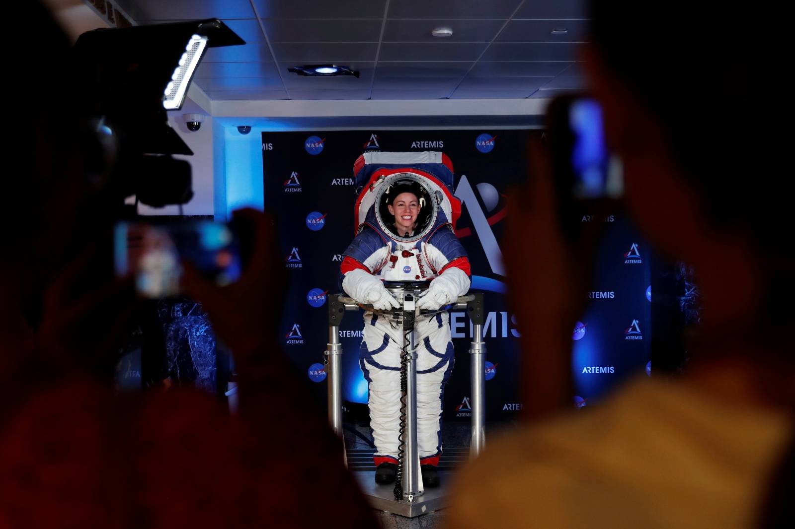 Visitors take pictures of Advanced Space Suit Engineer at NASA Kristine Davis as she wears the xEMU prototype space suit for the next astronaut to the moon by 2024,  during its presentation at NASA headquarters in Washington