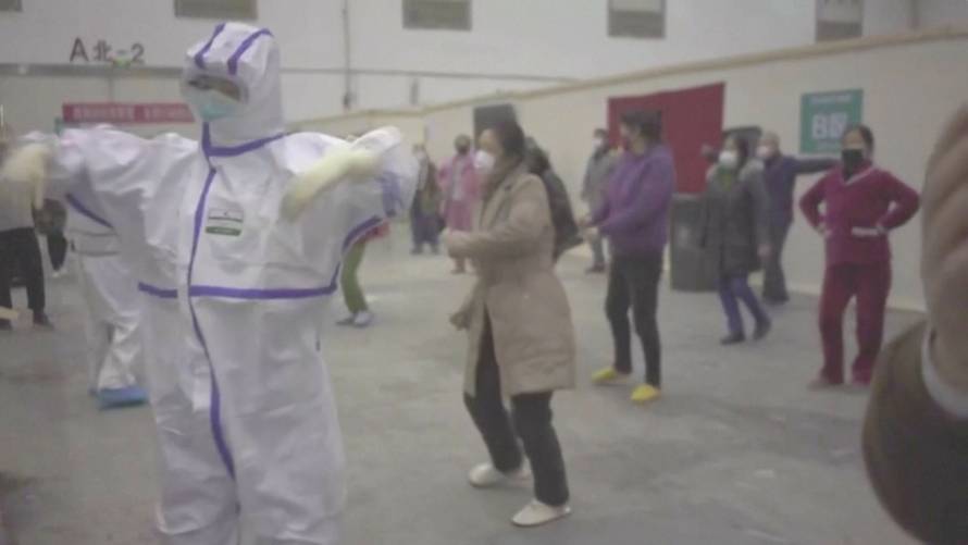 Coronavirus patients and medical staff dance to a lively Chinese song about red flowers at a makeshift hospital in Wuhan, China in this still frame obtained from video