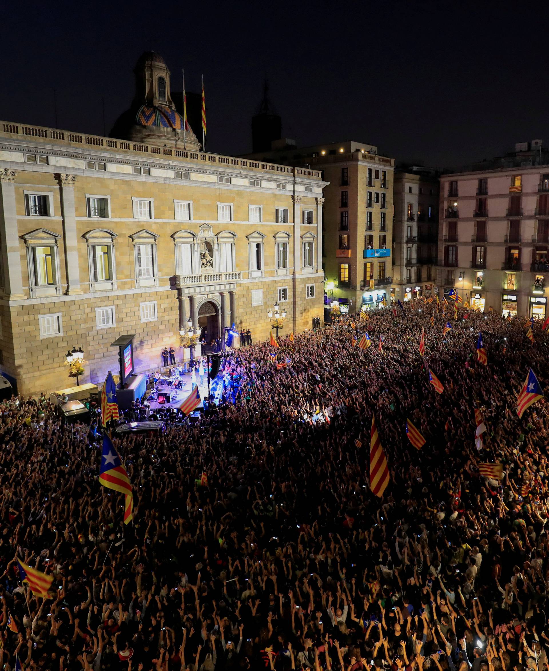 People raise arms as they gather during celebrations in Sant Jaume square after the Catalan regional parliament declared independence from Spain in Barcelona