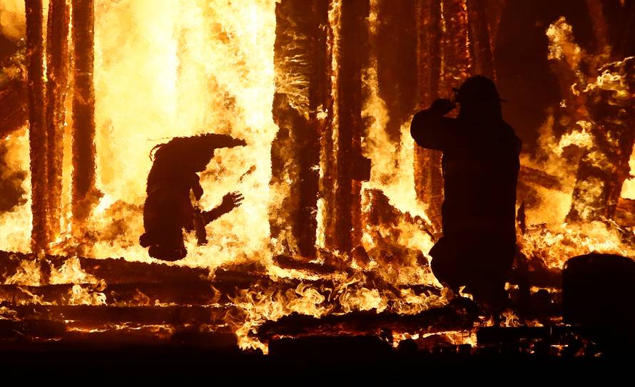 Burning Man participant runs into the flames of the "Man Burn" at the Burning Man arts and music festival in the Black Rock Desert of Nevada