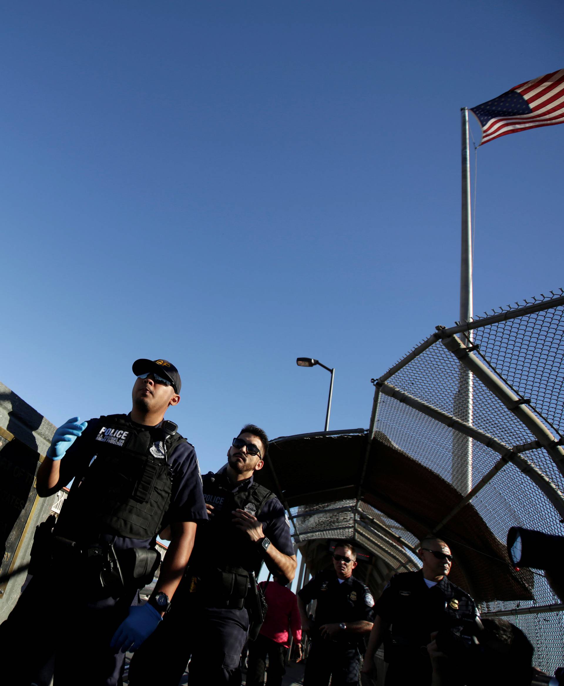 Officers of the U.S. Customs and Border Protection wait for migrants families from Mexico, fleeing from violence, to apply for asylum at Paso del Norte international border crossing bridge