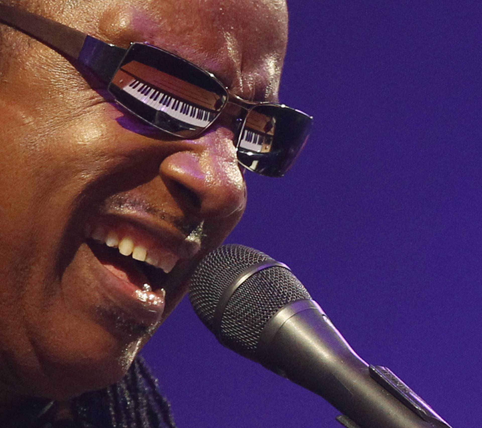 U.S. singer Stevie Wonder's piano is reflected in his sunglasses as he performs at the Glastonbury Festival 2010