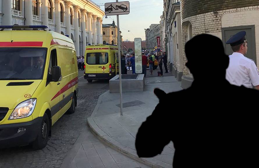 A police officer blocks the way as ambulances are parked near a damaged taxi, which ran into a crowd of people in central Moscow